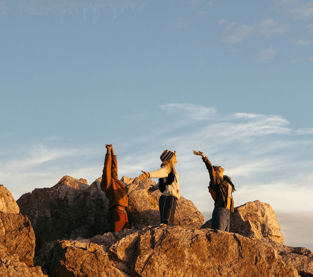 Travelers exploring rocky cliffs by the ocean